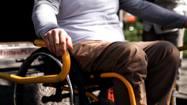 Rollstuhlfahrer vor Transportfahrzeug mit Rampe – Abrechnungslösungen für Krankentransport mit NOVENTI.