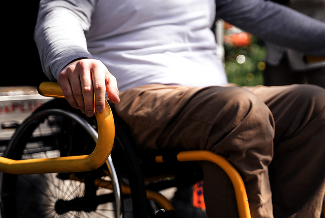 Rollstuhlfahrer vor Transportfahrzeug mit Rampe – Abrechnungslösungen für Krankentransport mit NOVENTI.