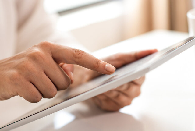 Therapeut lädt auf dem Tablett ein Dokument herunter – Symbolbild für NOVENTI Wissensangebot