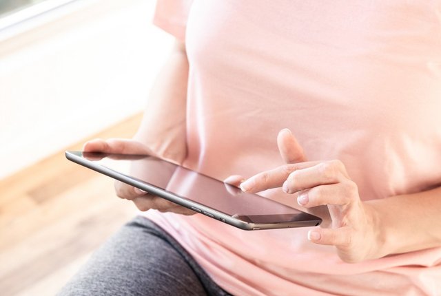 Heilmittelerbringerin informiert sich mit Hilfe eines Tablet über Befund und ICF