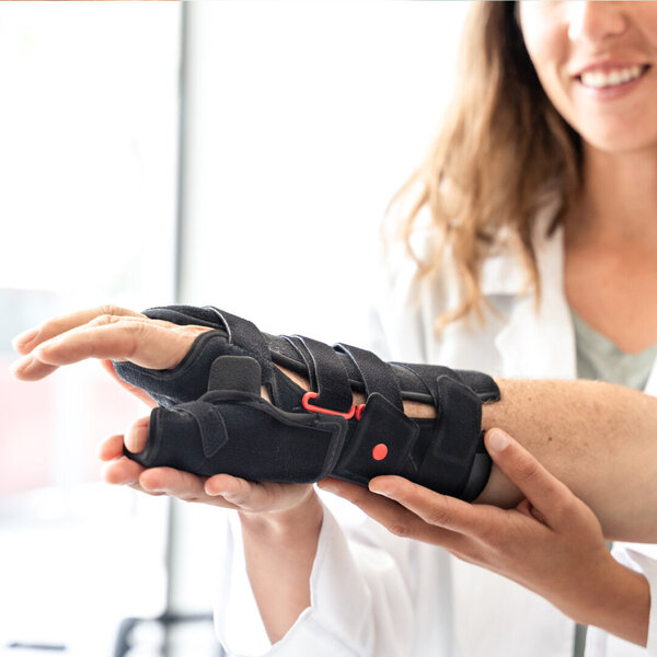 Älterer Mann beim Anprobieren einer orthopädischen Handgelenksorthese – Symbolbild für Hilfsmittel - Tipps zur Abrechnung mit einem Unfallversicherungsträger