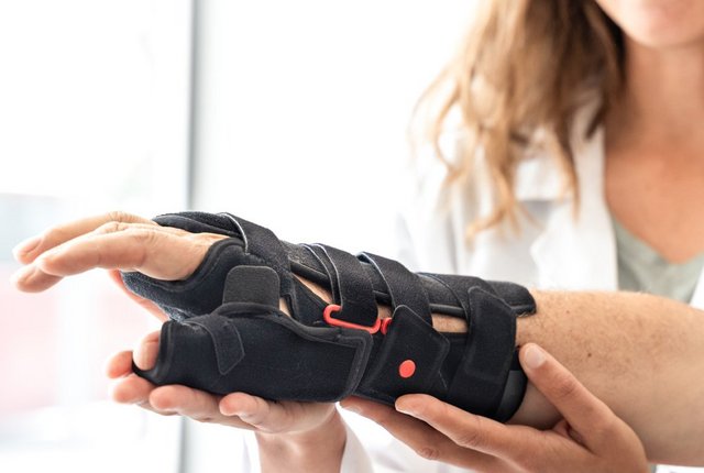 Älterer Mann beim Anprobieren einer orthopädischen Handgelenksorthese – Symbolbild für Hilfsmittel - Tipps zur Abrechnung mit einem Unfallversicherungsträger