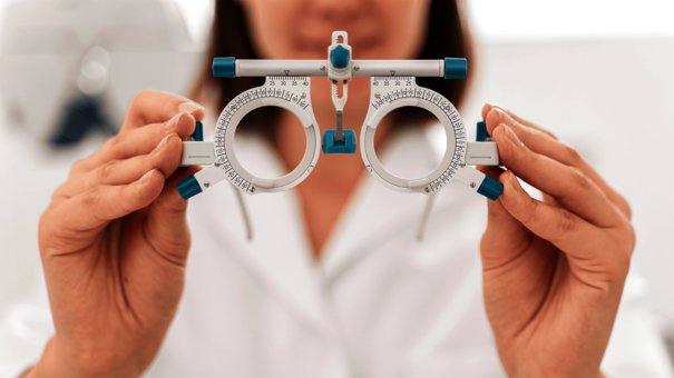 Optikerin hält ein Probierbrillengestell – elektronische Abrechnung in der Augenoptik mit NOVENTI.