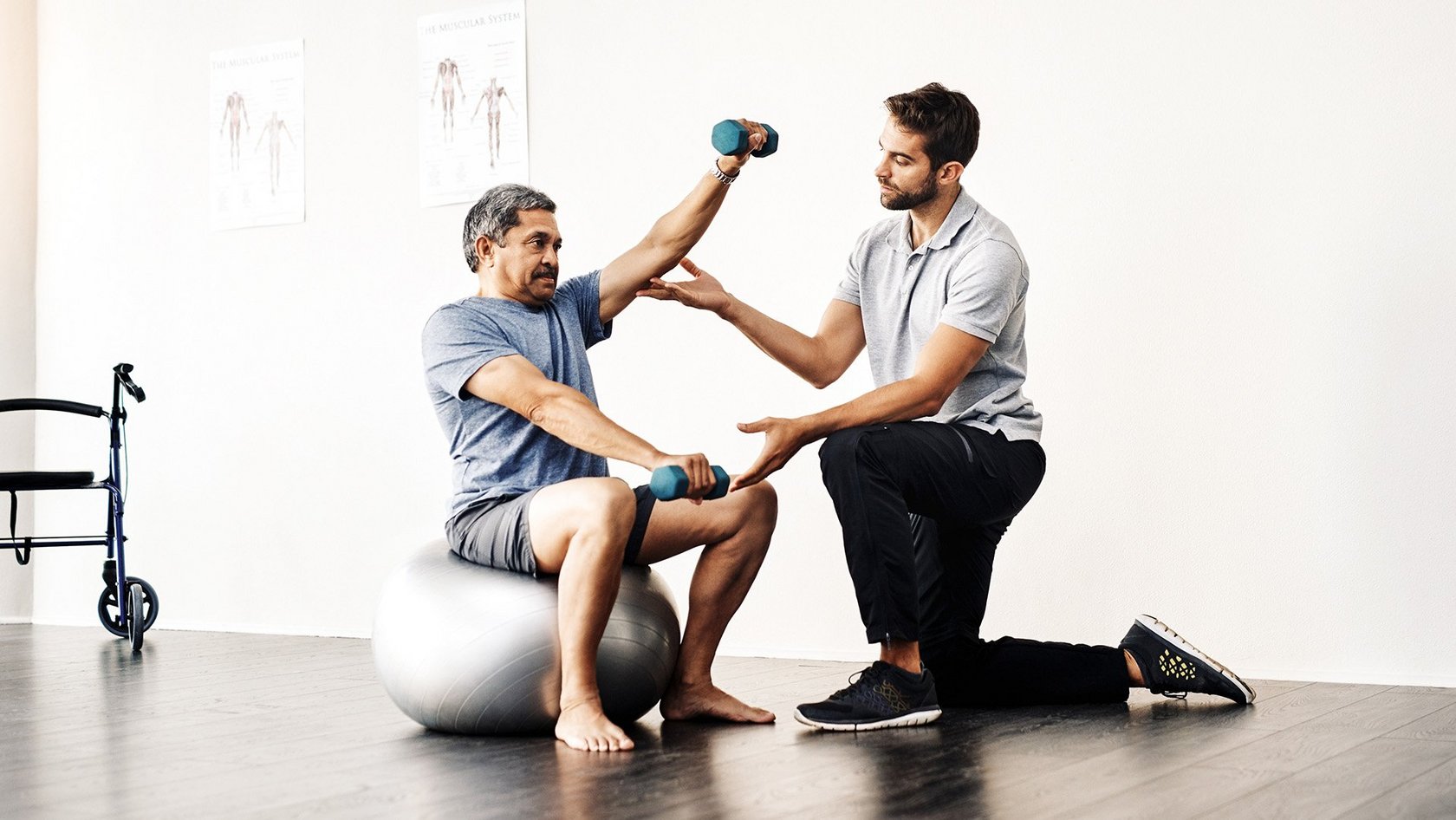 Physiotherapeut unterstützt älteren Patienten beim Training mit Hanteln – Symbolbild für moderne Physiotherapiepraxis und Vorbereitung auf die Telematikinfrastruktur-Förderung.