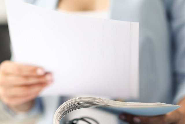 Therapeutin heftet ein Dokument im Aktenordner ab