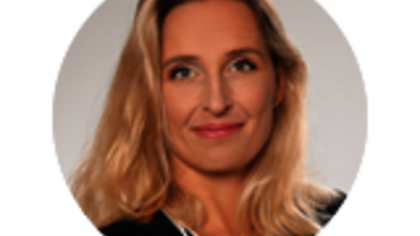Porträtaufnahme von Senior Sales Managerin Marie-Luise Wach mit hellen, Haaren, dunklem Oberteil und neutralem Hintergrund.