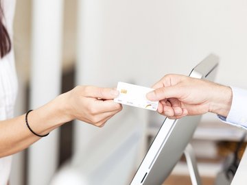 Patient übergibt seine Gesundheitskarte an Therapeutin – Symbolbild für TI-Anschluss