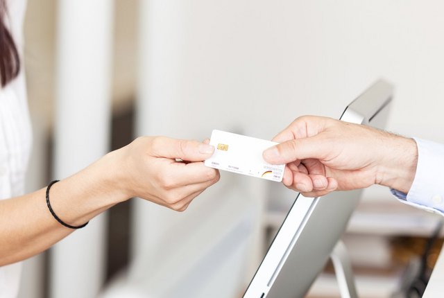 Patient übergibt seine Gesundheitskarte an Therapeutin – Symbolbild für TI-Anschluss