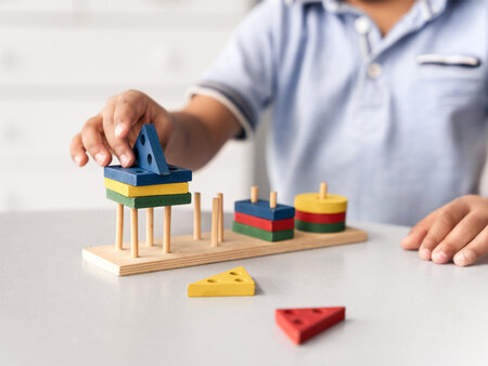 Nahaufnahme eines Kindes, das ein didaktisches Spiel genießt – Symbolbild für Ergotherapie – Tipps zur Abrechnung mit einem Unfallversicherungsträger