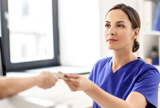 Ärztin und Patient mit Gesundheitskarte – Symbolbild für Entlassmanagement Krankenhaus