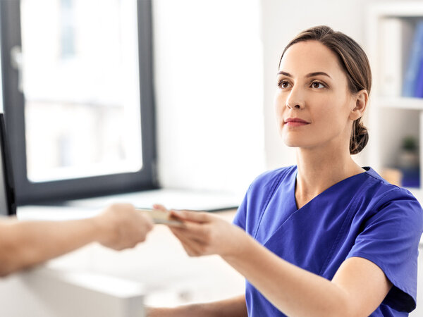 Ärztin und Patient mit Gesundheitskarte – Symbolbild für Entlassmanagement Krankenhaus