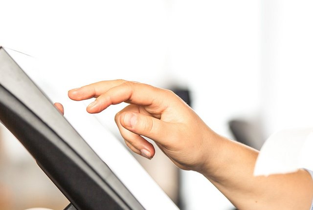Junge Verkäuferin erledigt Zahlungsvorgänge am Touchscreen – Symbolbild für TSE Technische Sicherheitseinrichtung 