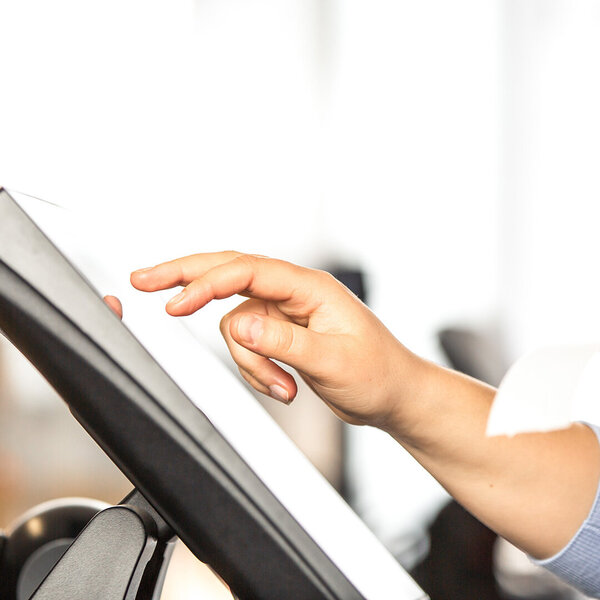 Junge Verkäuferin erledigt Zahlungsvorgänge am Touchscreen – Symbolbild für TSE Technische Sicherheitseinrichtung 