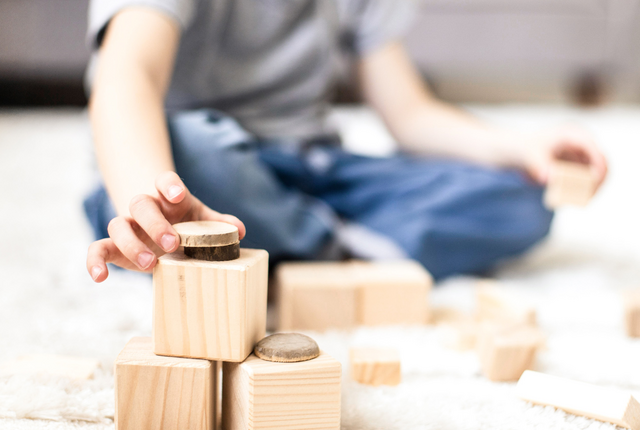 Ergotherapie - kleiner Junge spielt mit Bauklötzen
