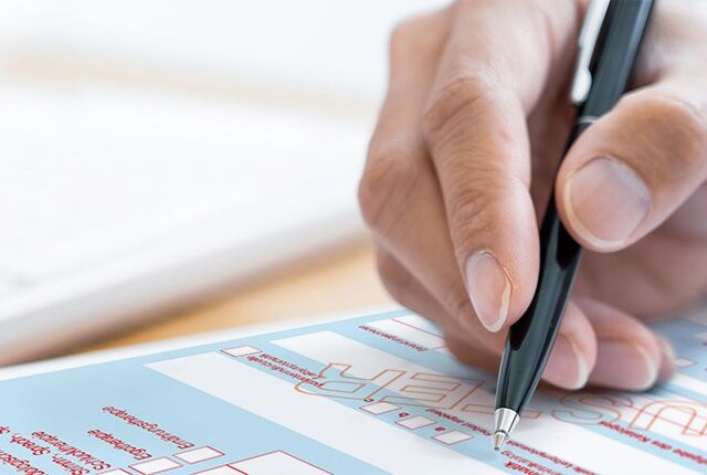 Hand mit Kugelschreiber füllt Heilmitterlverordnung Muster 13 aus