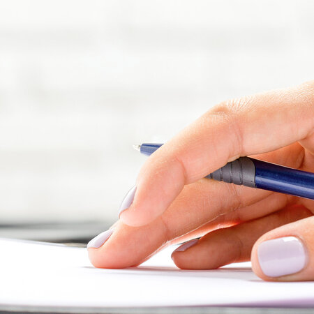 Hand mit Stift auf einem Schreibblock - Symbolbild für Heilmittelverordnung Korrekturmöglichkeiten