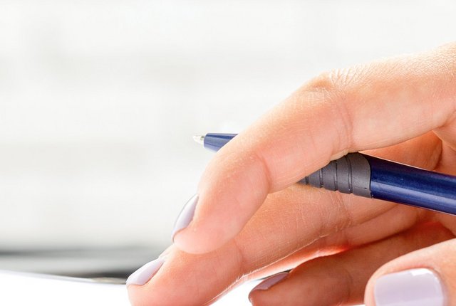 Hand mit Stift auf einem Schreibblock - Symbolbild für Heilmittelverordnung Korrekturmöglichkeiten