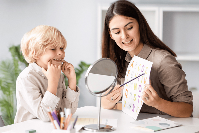 Logopädin übt mit Kind vor Spiegel – Logopädie korrekt abrechnen mit NOVENTI.