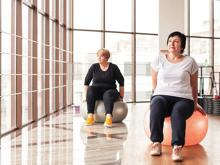 Zwei Frauen bei Rehasport-Übungen auf Gymnastikbällen in einem Trainingsraum – ambulante Bewegungstherapie mit digitaler Abrechnungslösung von NOVENTI.