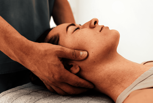 Therapeut behandelt Nacken einer Patientin – Abrechnung für Massageleistungen mit NOVENTI.