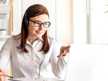 Teilnehmerin eines NOVENTI Online-Seminar sitzend vor dem Notebook – Symbolbild für NOVENTI Akademie