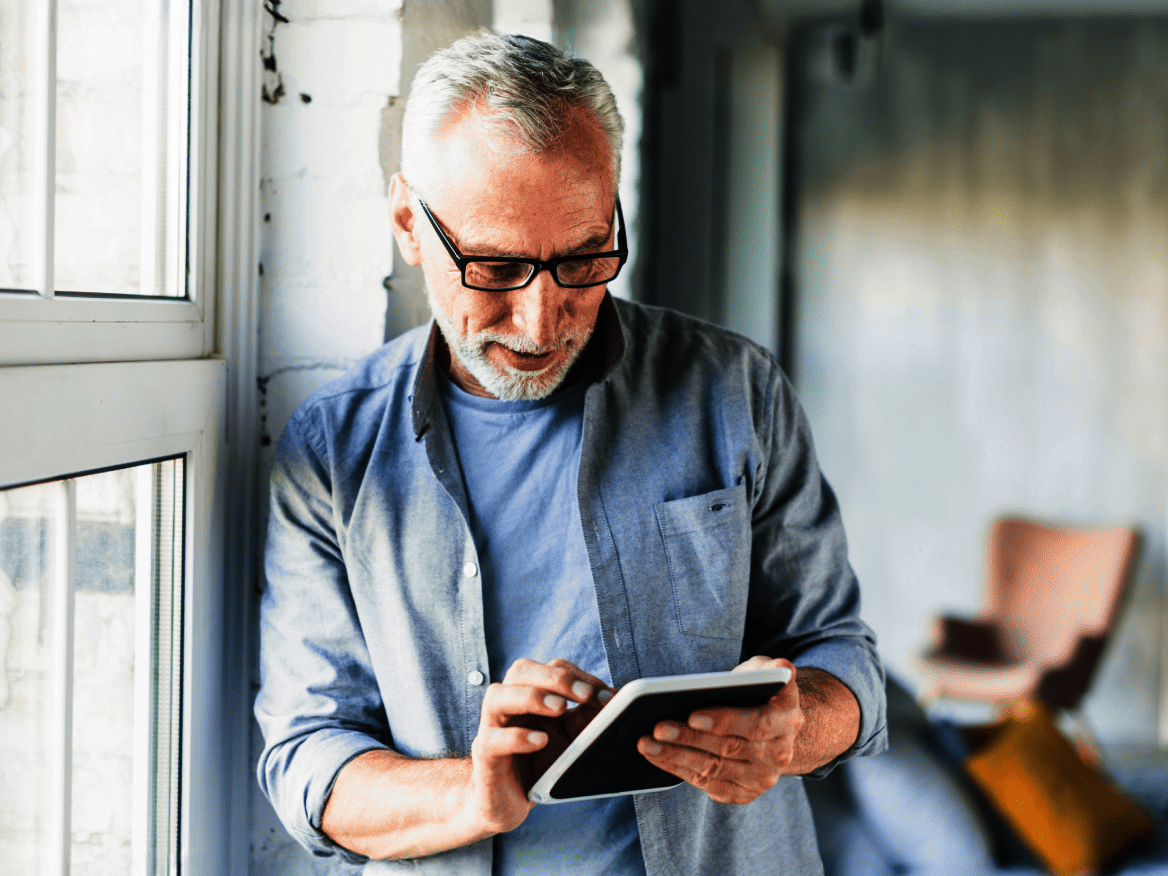 Älterer Mann der sich mit einem iPad über die NOVENTI Software informiert