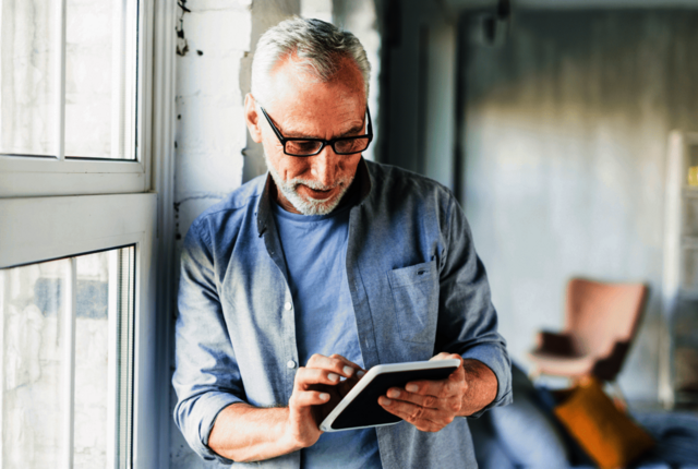 Älterer Mann der sich mit einem iPad über die NOVENTI Software informiert