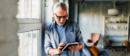 Älterer Mann der sich mit einem iPad über die NOVENTI Software informiert
