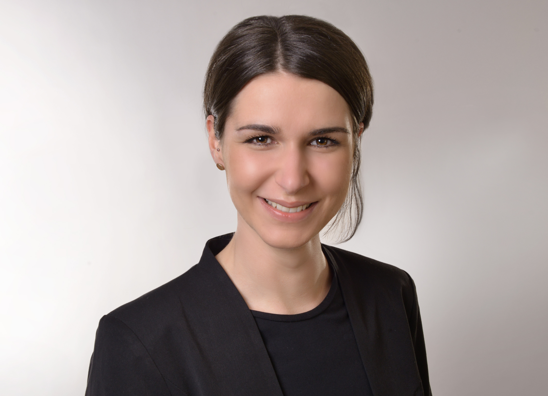 Porträtaufnahme von Marketingmanagerin Katherina Steyrer mit dunklem Haar, schwarzem Blazer, vor hellem Hintergrund, frontal aufgenommen.