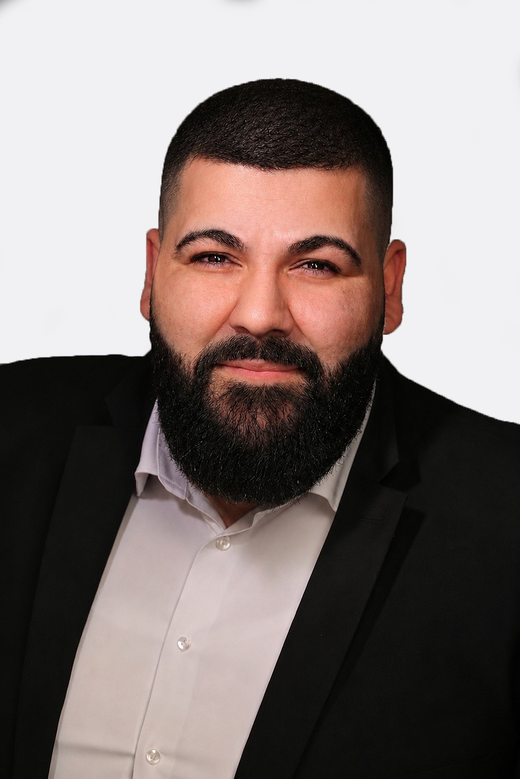 Porträtaufnahme von Sales Manager Berat Cetin mit kurzer Frisur und dunklem Sakko vor neutralem, hellem Hintergrund.