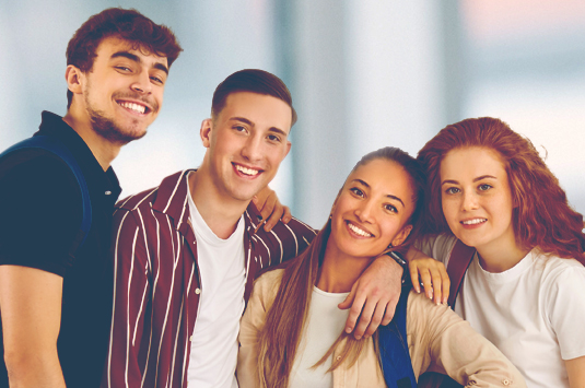 Vier Schüler lächeln in die Kamera